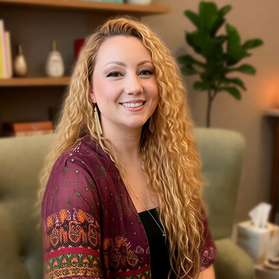 Larissa Martinne - Terapeuta Integrativa e mentora de desenvolvimento pessoal sentada em seu consultório.